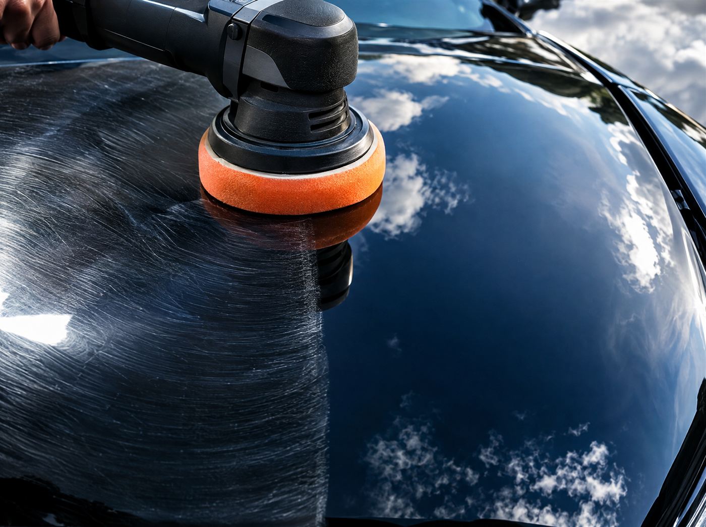 Machine polisher removing swirl marks from black paint